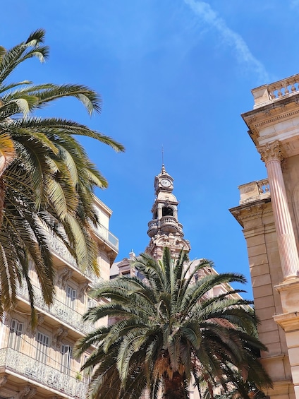 A historic building with ornate balconies and a clock tower. 1
