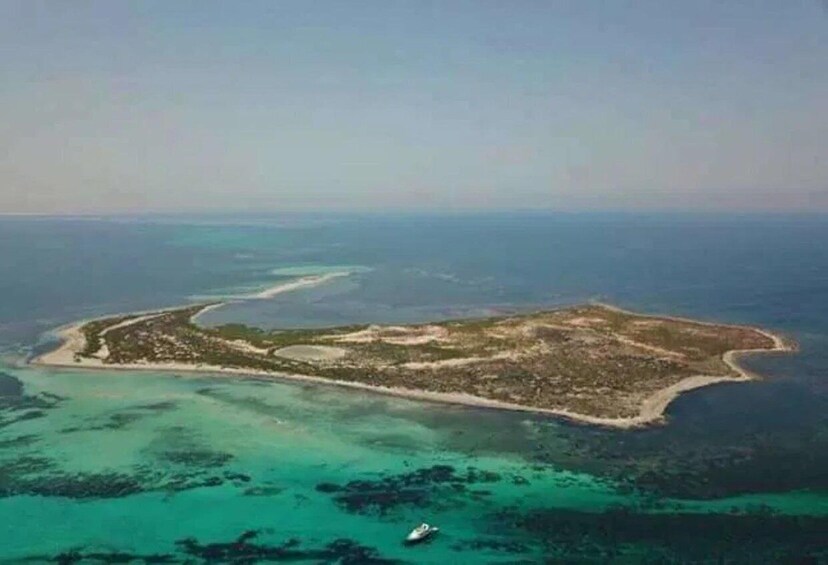 An aerial view of a small island with clear turquoise waters and a boat in the foreground. 4