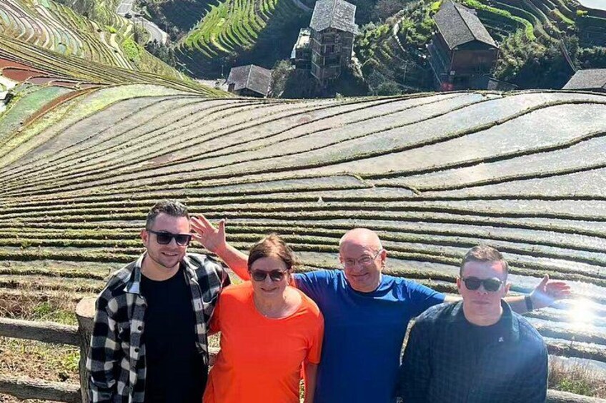 A group of people standing in a terraced vineyard with rows of grapevines. 3