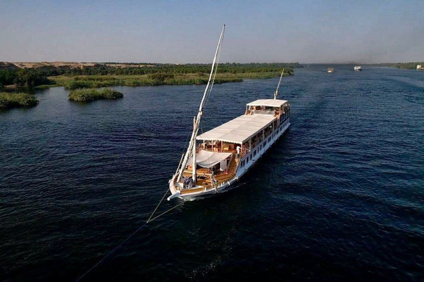 A large boat on a river with greenery on the banks. 5