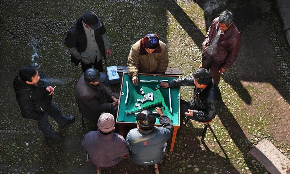A group of people playing a game of pool outdoors. 5
