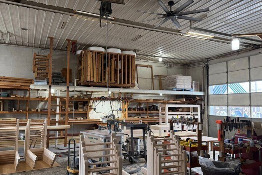 A workshop with wooden planks, tools, and machinery. 3