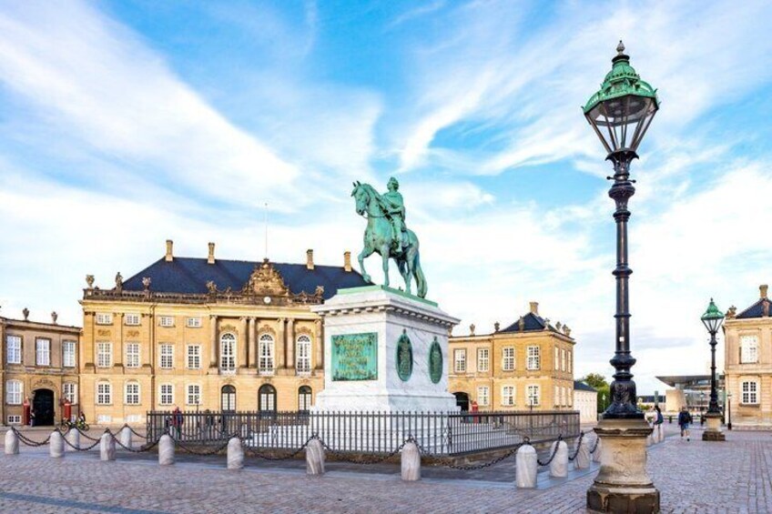 En staty som föreställer en ryttare på hästryggen, ett torg med kullersten och historiska byggnader. 5