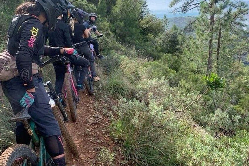 Un groupe de vététistes sur un sentier de terre, entouré de verdure. 3
