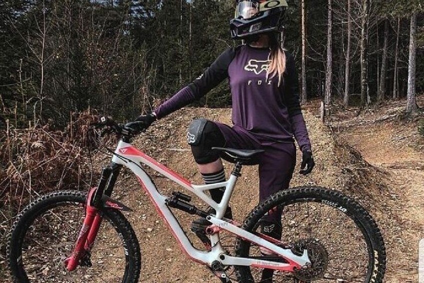 Une personne à vélo tout-terrain, portant un casque, dans une zone boisée. 2