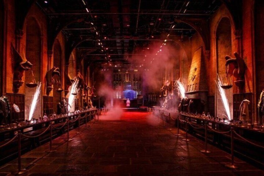 An indoor venue with arched ceilings, a central stage, and rows of tables. 3