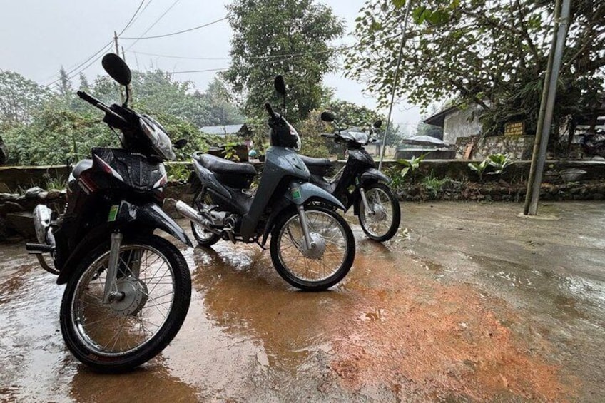 Two motorcycles parked on a wet surface with puddles. 4