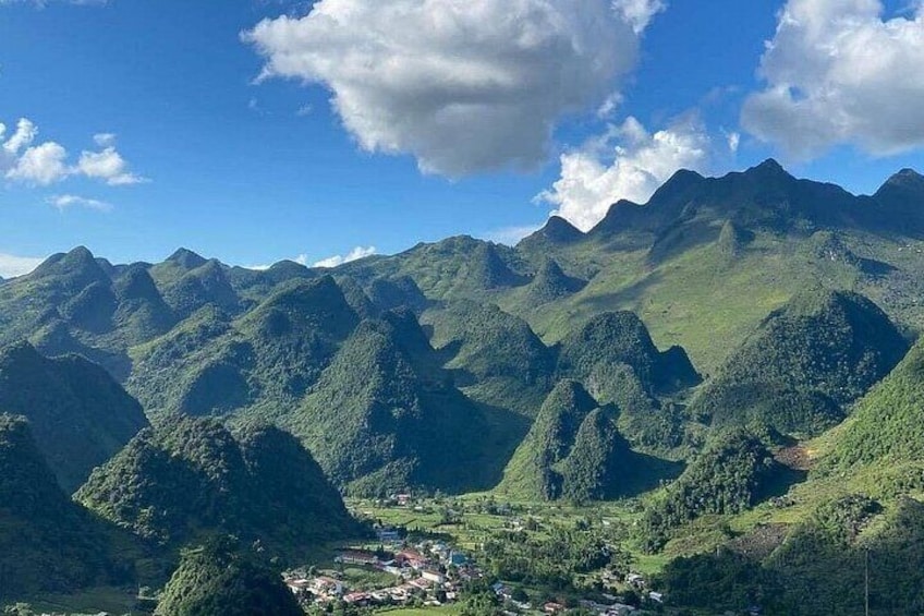 A mountainous landscape with a valley and a small settlement. 1