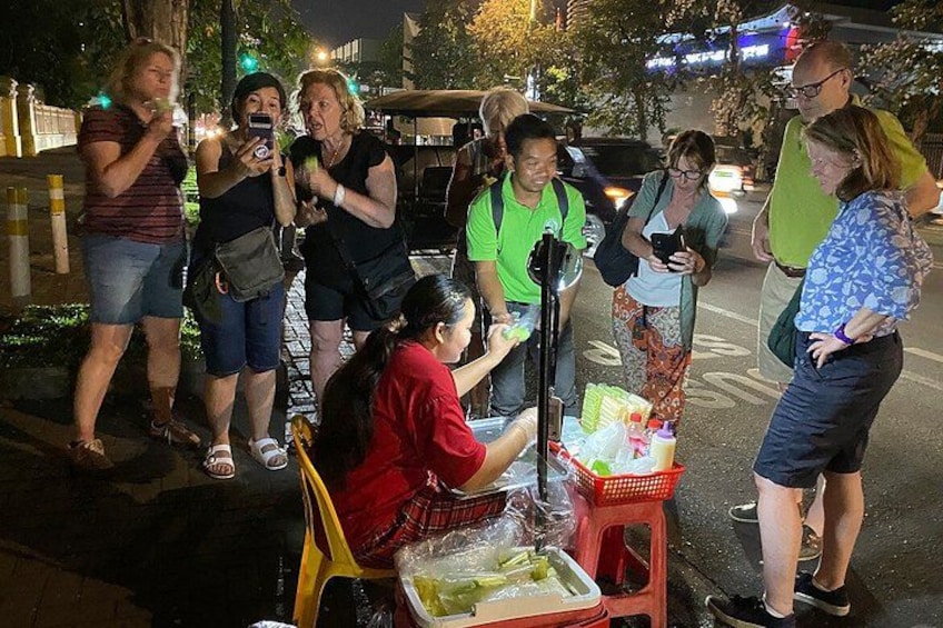 A street food vendor with a cart, surrounded by people. 2