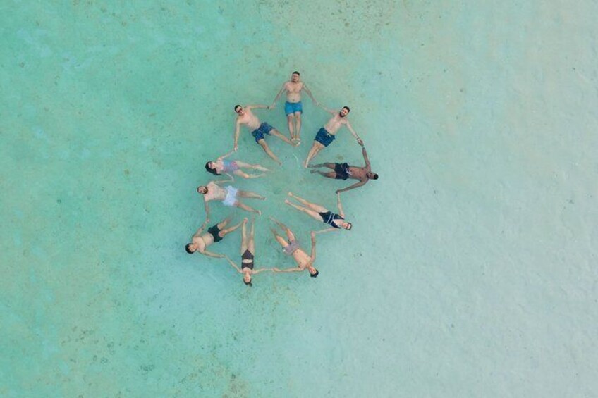 A group of people lying on a beach in a circle. 2