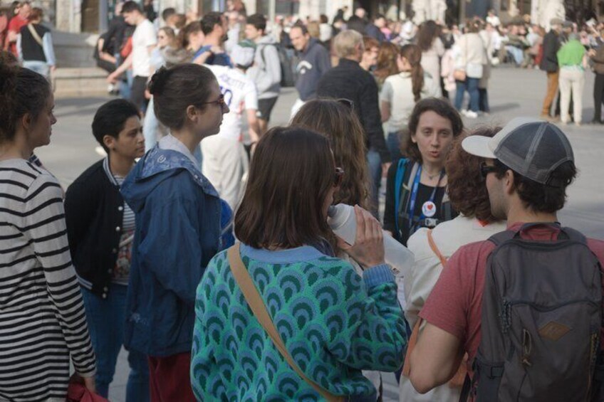 A group of people standing in a public square. 5