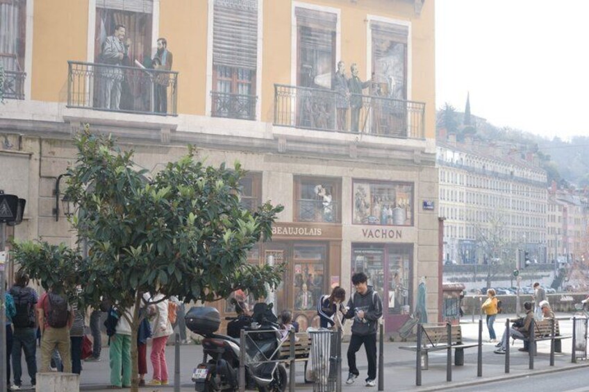 A busy street with people, a tree, and storefronts including 'BEAUJOLIS' and 'VACHON'. 4