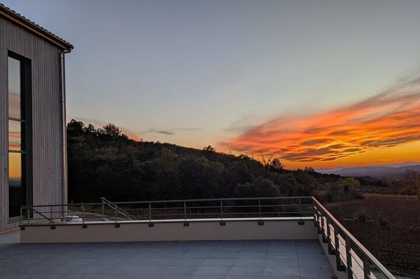 A modern building with a balcony overlooking a sunset. 3