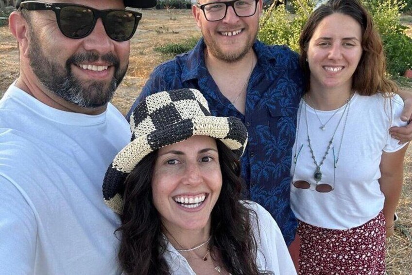 A group of people outdoors, with one person wearing a checkered hat. 3