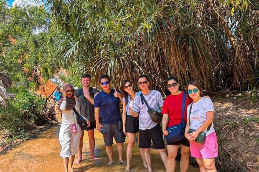 A group of people standing on a dirt path surrounded by tropical vegetation. 3
