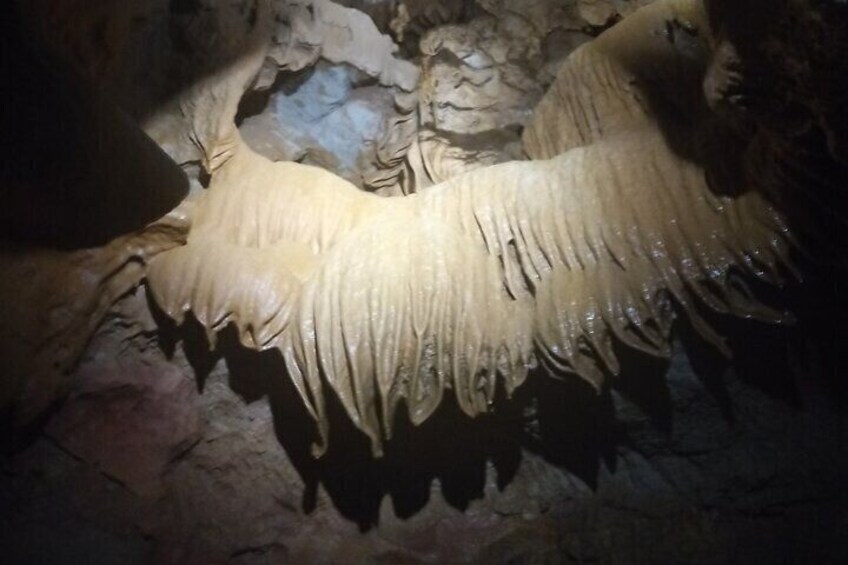 A cave with stalactites hanging from the ceiling. 4