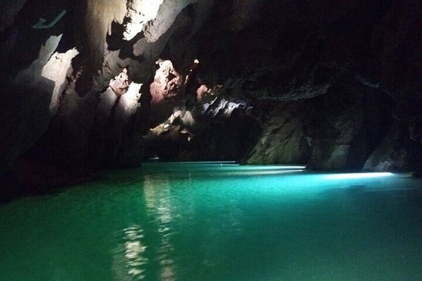 Una cueva con un estanque de agua y formaciones rocosas. 2