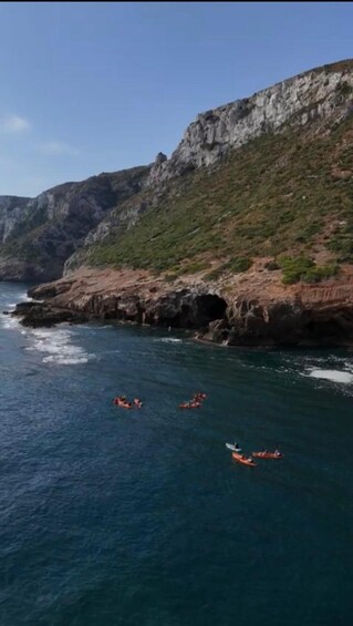 Kayakers on a coastal sea with rocky cliffs. 2