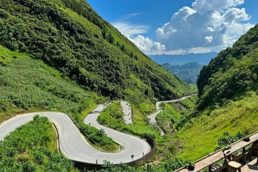 A winding mountain road surrounded by lush greenery and hills. 3