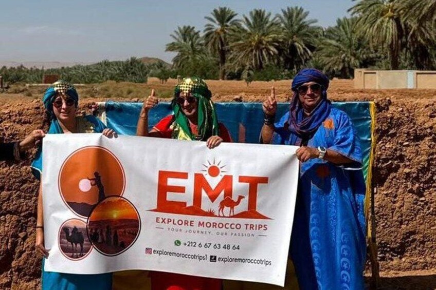 Three people holding a banner with the text 'EMT Explore Morocco Trips.' 1