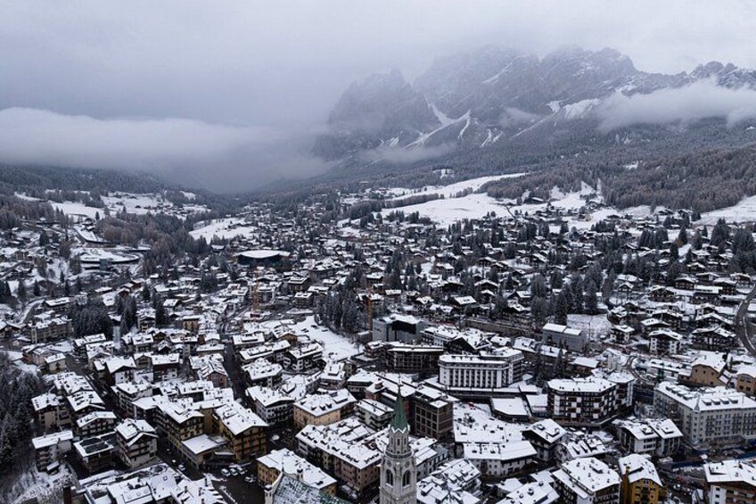 Une ville enneigée, avec des bâtiments, une église et des montagnes en arrière-plan. 3