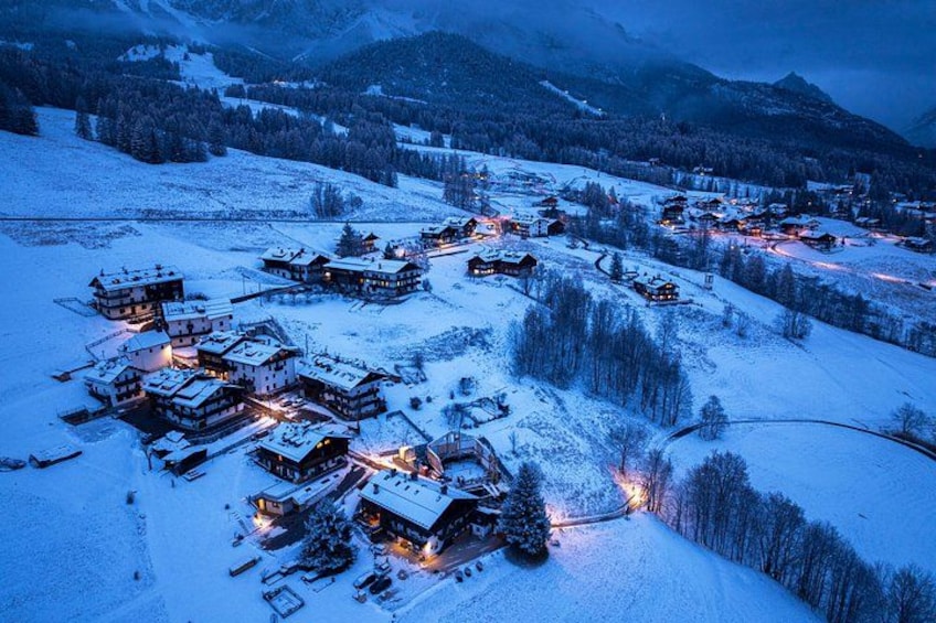 Un village enneigé, avec des bâtiments et une route sinueuse. 2
