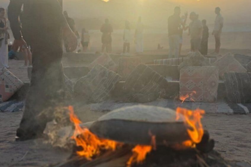 A beach scene with people, a fire, and scattered debris. 3