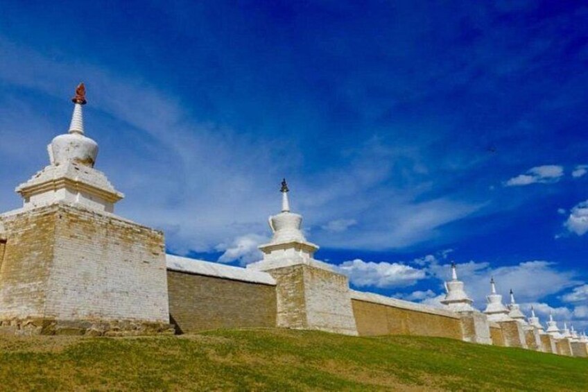 A row of white stupas with a clear blue sky in the background. 5
