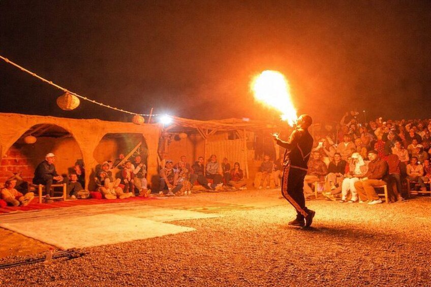 Une personne qui se produit en manipulant une torche enflammée dans un lieu extérieur, la nuit. 5