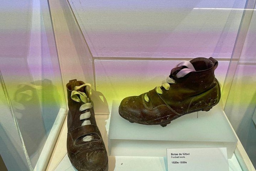 Un par de botas de fútbol antiguas en una vitrina. 2