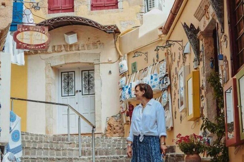 A narrow street with a building entrance, a staircase, and a woman standing in front. 3