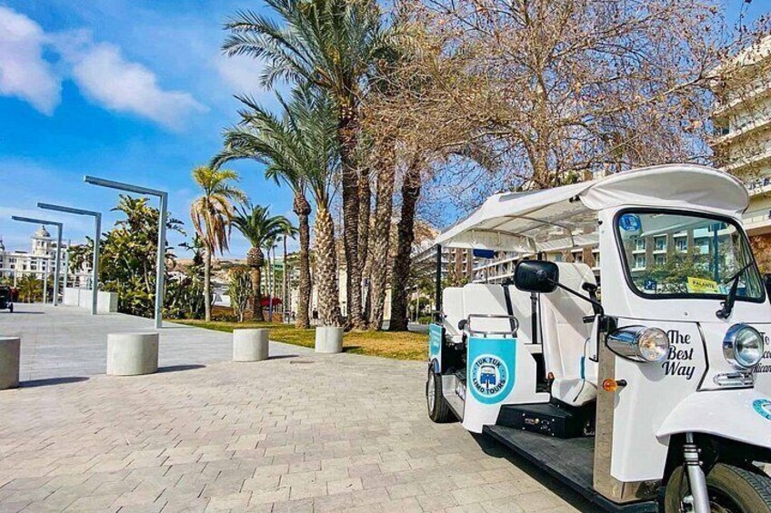 A white delivery truck parked on a paved area with palm trees and a clear sky in the background. 5