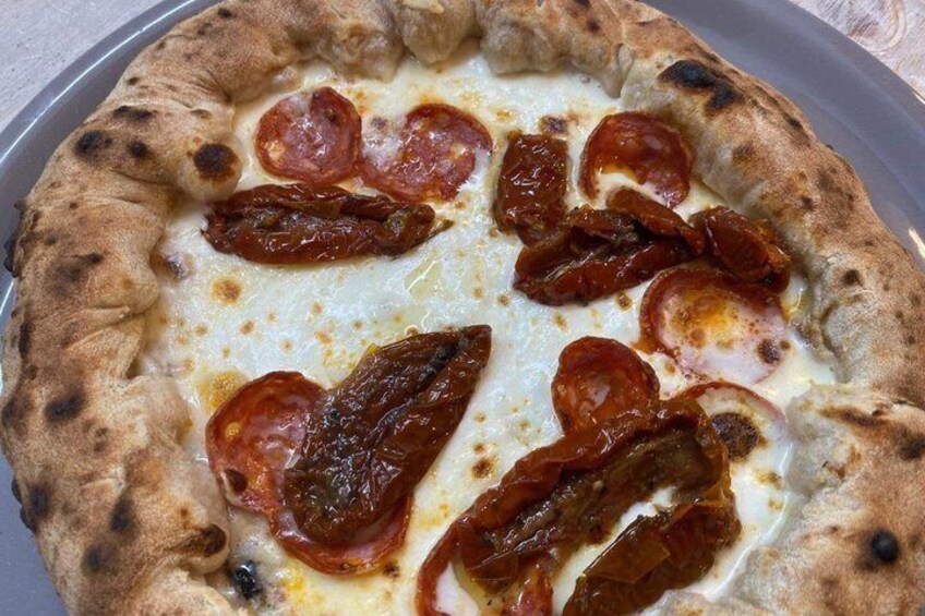 Pizza con pepperoni e formaggio su un vassoio di metallo. 2