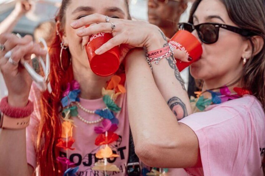 Two people wearing colorful clothing and drinking from red cups. 5