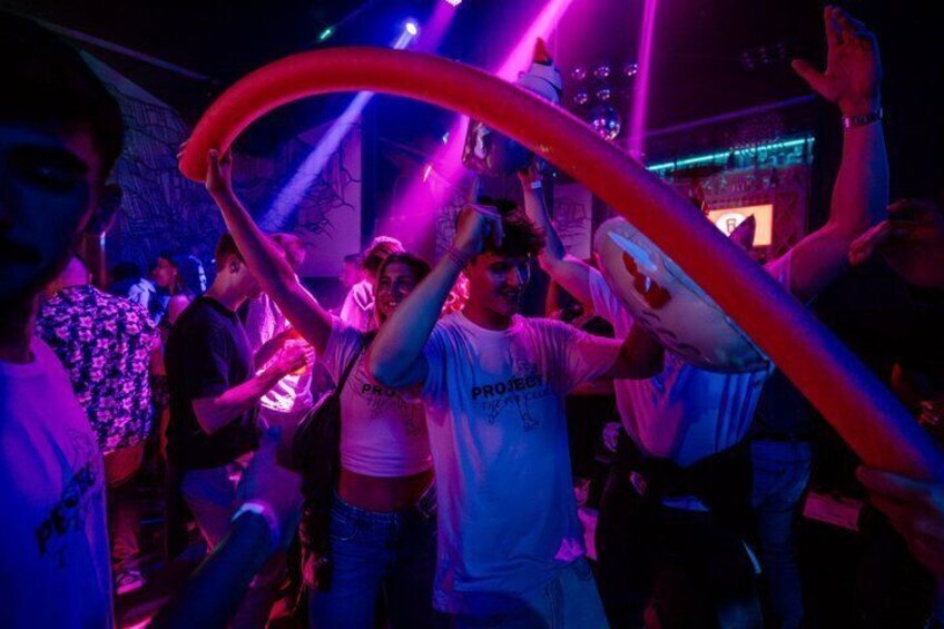 People dancing in a club with purple lighting. 2