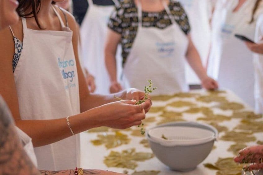 People wearing aprons, holding small plants, and a bowl on a table. 3