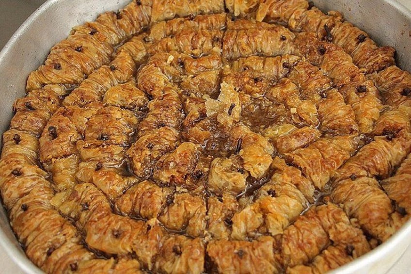 A tray of baked pastries, likely a type of savory pastry, arranged in a circular pattern. 2