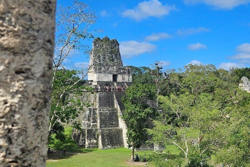 Una pirámide maya con una escalera que conduce a un templo, rodeada de exuberante vegetación. 4