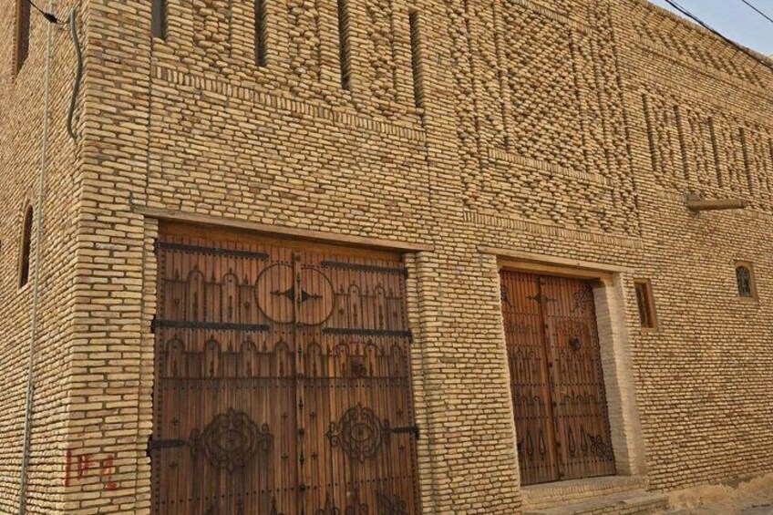 A brick building with two large wooden doors and a smaller door. 1