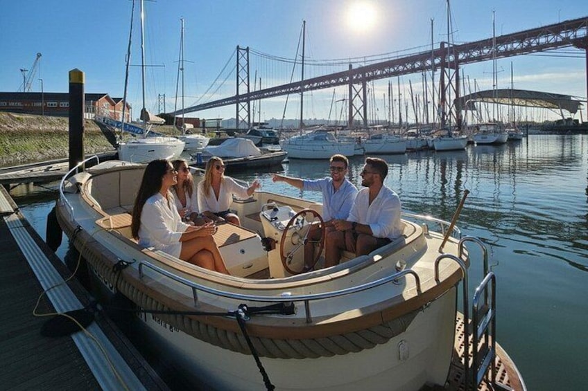 A group of people on a small boat at a marina with a bridge in the background. 2