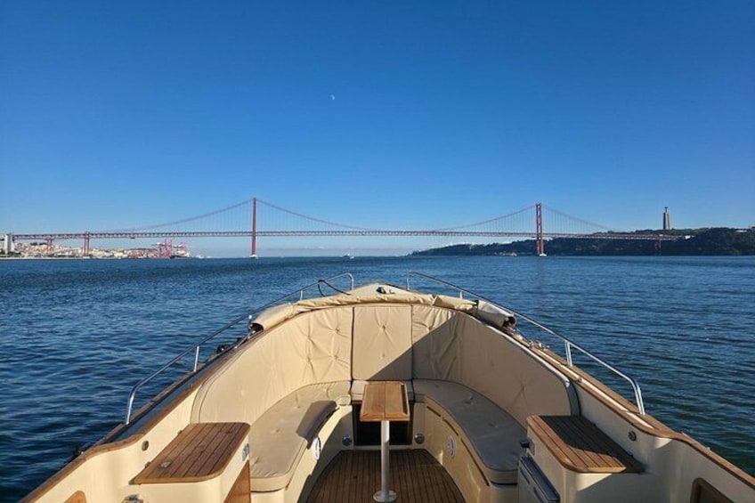 A boat on calm water with a red bridge in the background. 3