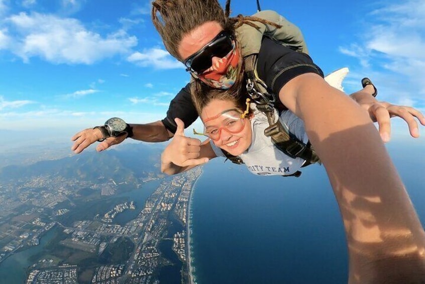 Ein Fallschirmspringer, eine Person die ein Selfie macht und eine Küstenlandschaft im Hintergrund. 1