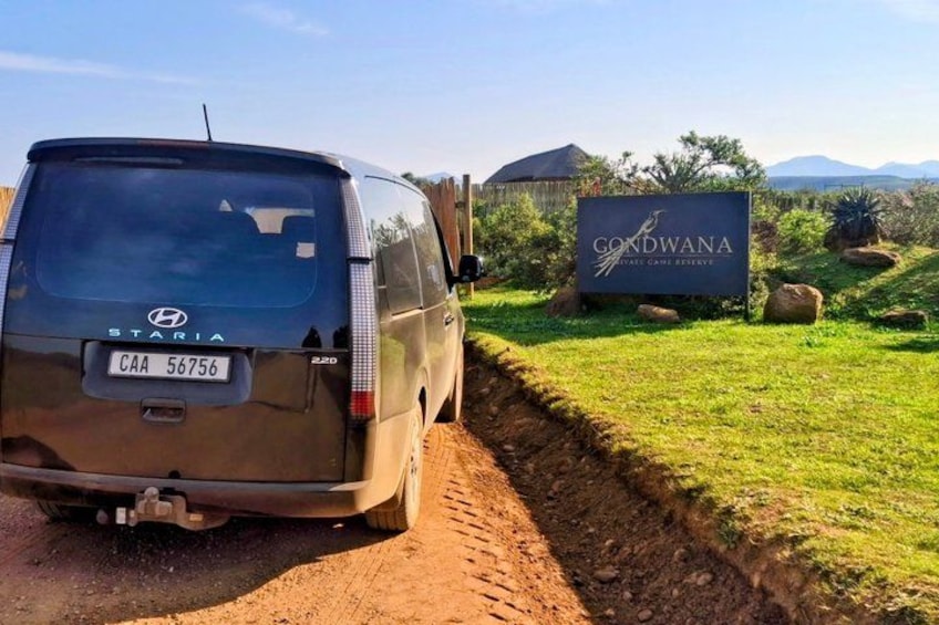 A Hyundai Staria van parked on a dirt road, a sign for 'Gondwana', and a grassy area with rocks. 4