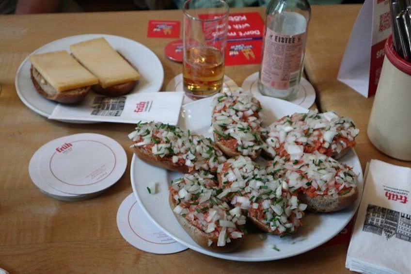 A table with plates of bruschetta and a bottle of beer. 4