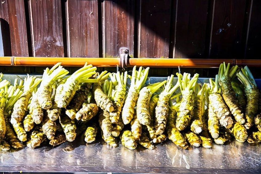 A row of fresh ginger roots hanging on a metal rack. 3
