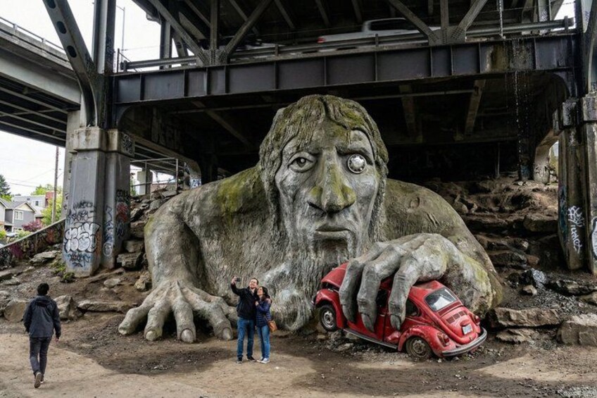 En stor stenskulptur som föreställer en man med en bil under en bro. 3