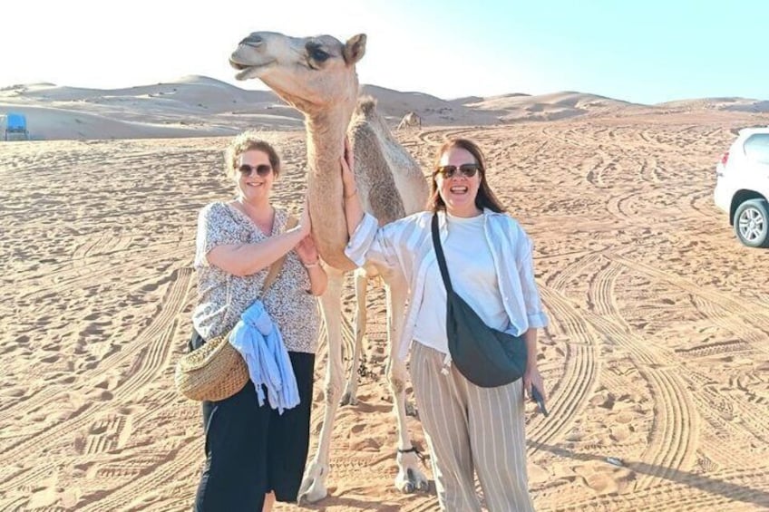 Two people with a camel in a desert landscape. 4