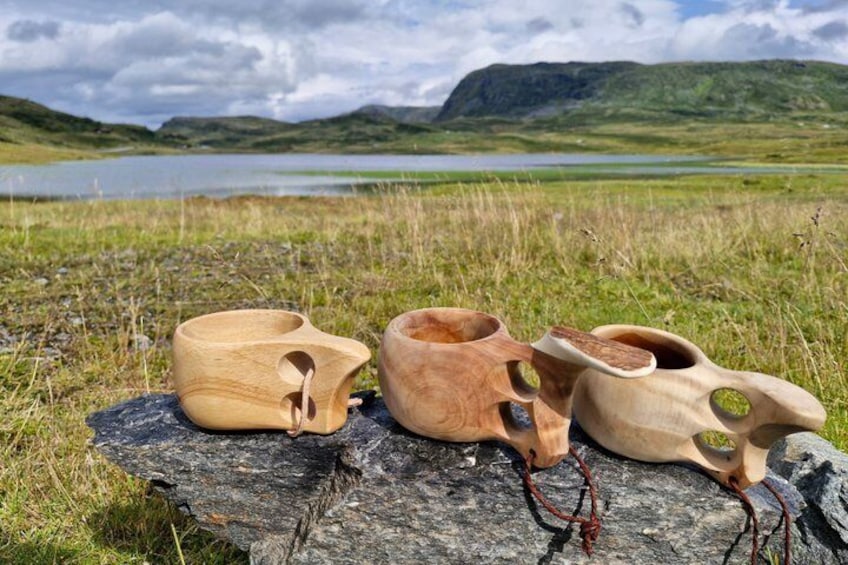 Three wooden bowls on a rock by a lake with hills in the background. 2