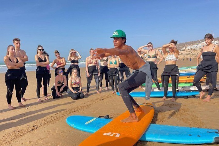 Eine Gruppe von Menschen am Strand mit Surfbrettern. 1