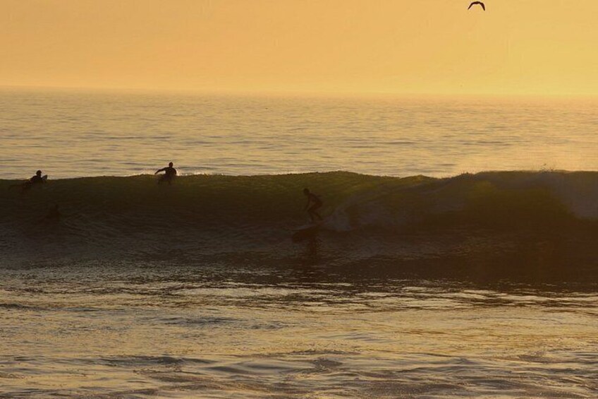 Surfer reiten Wellen bei Sonnenuntergang. 3